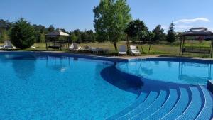 a large swimming pool with blue water at Lighthouse Golf Private Villa Lake view in Balchik