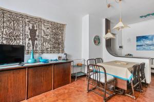 une salle à manger avec une table et une télévision dans l'établissement Camogli Bright Apartment with Parking, à Camogli