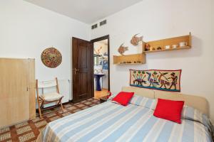 - une chambre avec un lit et 2 oreillers rouges dans l'établissement Camogli Bright Apartment with Parking, à Camogli