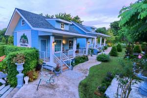 a blue house with a garden at Little Cottage in Chanthaburi