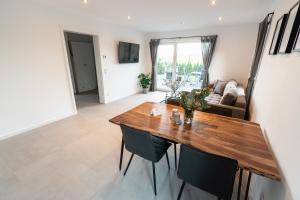 un salon avec une table et des chaises en bois dans l'établissement Ostseehaus am Naturstrand - Ostseeblick, à Varnkevitz