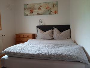 1 dormitorio con cama y tocador de madera en Gästehaus Koch en Zöblen