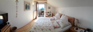 a bedroom with a bed with a comforter and a window at Gästehaus Alpenblick in Innsbruck