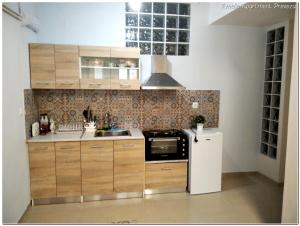 a kitchen with wooden cabinets and a white refrigerator at Amelie Apartment in Preveza +22 photos