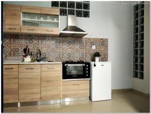 a kitchen with wooden cabinets and a white refrigerator at Amelie Apartment in Preveza