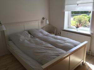 a bed in a room with a window at Herlebo in Tønder