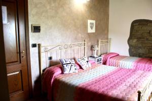 a bedroom with two beds with pink sheets at Agriturismo La Fine in Piancaldoli