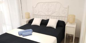 - une chambre avec un lit noir et blanc et des oreillers blancs dans l'établissement SCALA Apartaments, à Salou 21 autres photos