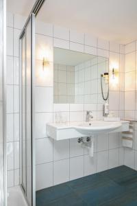 bagno con lavandino e specchio di Hotel Alpenblick a Weissbad