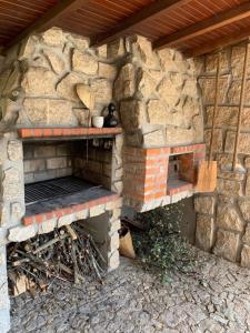 un horno de ladrillo al aire libre con un objeto negro. en Casa da Montanha en Rebordões