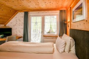 Schlafzimmer mit einem Bett und einem Fenster in der Unterkunft Hotel Alpenblick in Weissbad