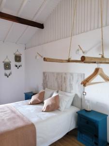 a bedroom with a bed with white sheets and pink pillows at Casa da Montanha in Rebordões