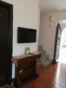 sala de estar con TV de pantalla plana en la pared en Casa Corsetta, en Alvito