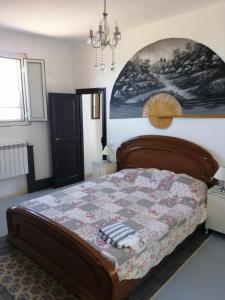 una camera da letto con un letto e un dipinto sul muro di Casa Corsetta ad Alvito
