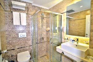 a bathroom with a shower and a sink and a toilet at Club Big Blue Suit Hotel - All Inclusive in Alanya