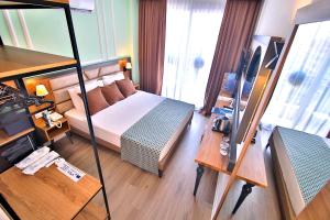 um quarto de hotel com uma cama e uma televisão em Club Big Blue Suit Hotel - All Inclusive em Alanya