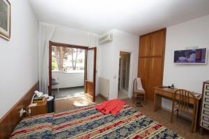 a bedroom with a bed and a desk and a bathroom at Hotel Santa Caterina in Marina di Campo