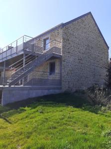 un bâtiment en briques avec un escalier sur son côté dans l'établissement L’Ancienne Grange 1916, à Chevetogne