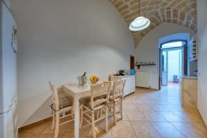 una cucina e una sala da pranzo con tavolo e sedie di Corte Anibaldi Apartment a Lecce