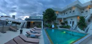 a house with a swimming pool with lounge chairs and a house at Mui Ne Hills Villa Hotel in Mui Ne