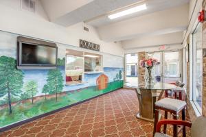 uma sala de jantar com um mural de uma quinta na parede em OYO Hotel Mona Lake Muskegon em Muskegon