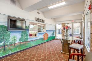 a dining room with a mural of a farm on the wall at OYO Hotel Mona Lake Muskegon in Muskegon