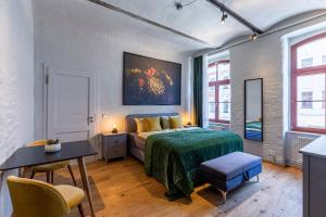 - une chambre avec un lit, une table et des chaises dans l'établissement Loft Apartment Verde, à Leipzig
