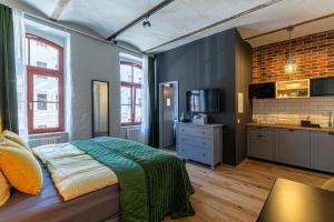 ein Schlafzimmer mit einem großen Bett und eine Küche in der Unterkunft Loft Apartments Leipzig Loft Verde in Leipzig