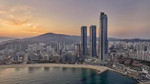 a city with tall buildings and a sky background at Signiel Busan in Busan
