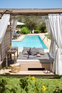 a bed sitting in front of a swimming pool at Can Arabí in Ibiza Town