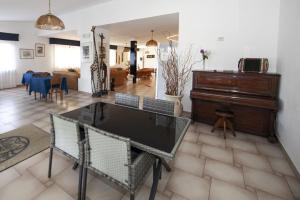 a living room with a table and a piano at Hotel Santa Caterina in Marina di Campo