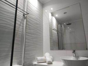 a bathroom with a shower and a sink and a mirror at Orion Apartments in Malia