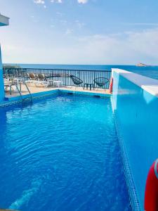 a swimming pool with the ocean in the background at Hotel Marconi in Benidorm