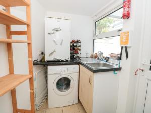 a kitchen with a washing machine and a sink at Anchor Cottage in Salcombe +35 photos