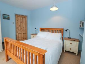 ein Schlafzimmer mit einem großen Bett mit einem hölzernen Kopfteil in der Unterkunft Anchor Cottage in Salcombe