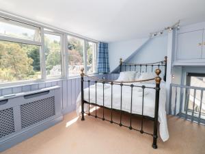 a bedroom with a bed in a room with windows at Anchor Cottage in Salcombe