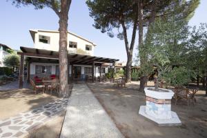 a house with a patio with tables and chairs at Hotel Santa Caterina in Marina di Campo
