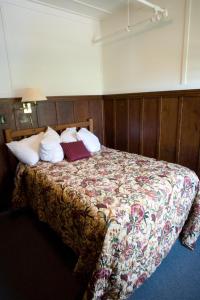 a bedroom with a bed with a floral bedspread at Prince of Wales Hotel in Waterton Park