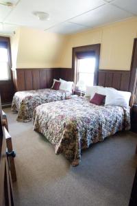 two beds in a hotel room with two bedsskirtspectspectssenalsenal at Prince of Wales Hotel in Waterton Park