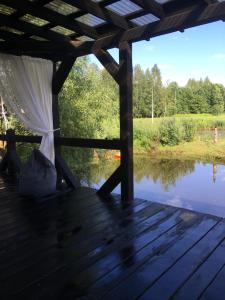 une terrasse en bois avec vue sur le lac dans l'établissement Stay at hosts, à Rēzekne