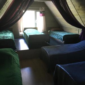 Cette chambre mansardée comprend 3 lits et une fenêtre. dans l'établissement Stay at hosts, à Rēzekne