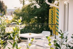 a white table and chairs on a balcony at Boutiquehotel Caravella Velden by S4Y in Velden am Wörthersee