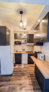 a kitchen with a white refrigerator and wooden floors at Appartement Ajaccio vue mer panoramique in Ajaccio