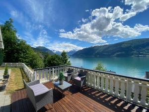 a deck with chairs and a view of a lake at Faleide Panorama by Homes & Villas in Stryn