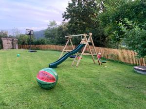 a playground with a slide and a ball on the grass at Chalupa Hubertus in Zátoň