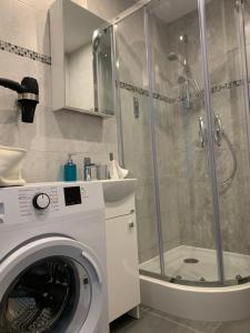 una lavatrice in un bagno con doccia di Apartament Zabia a Białystok