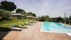 a swimming pool with chairs and umbrellas next to it at Casa Olivi Apartments in Bardolino