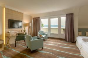 a hotel room with a bed and a desk and chairs at Hotel Der Seehof in Ratzeburg