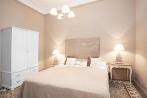 バルセロナにあるBCN ランブラ カタルーニャ アパートメンツのベッドルーム(大きな白いベッド1台、ランプ2つ付)