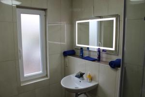 a bathroom with a sink and a mirror and a window at Ferienhaus „Strandhafer“ in Zingst